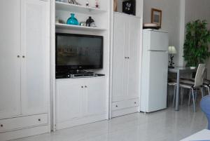 a living room with white cabinets and a tv at Carabeo 15 Studios Casasol in Nerja