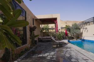 a house with a swimming pool next to a building at Voyage Itlalat Resort منتجع وشاليهات فوياج اطلالات in Al ‘Uyaynah