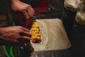 a person preparing food on top of a pan at Homestay & Trekking Sapa Tom Tom in Sa Pả