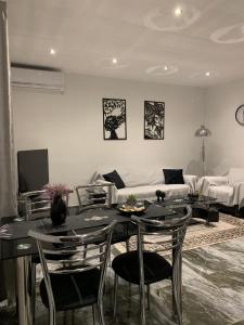Una sala de estar con una mesa y sillas y un sofá. en Villa THEO, en Kallithea Halkidikis 26 fotos más