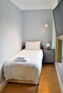a bedroom with a white bed and a night stand at Bowood Park Hotel in Camelford