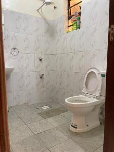a white bathroom with a toilet and a sink at Stylish Studio Apt in Ruiru Membly, Near Tatu City in Ruiru
