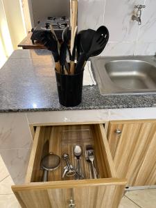 a kitchen drawer with utensils in it next to a sink at Stylish Studio Apt in Ruiru Membly, Near Tatu City in Ruiru