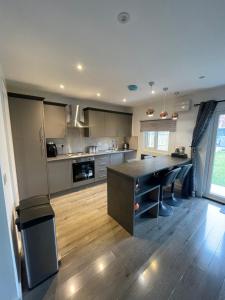 a large kitchen with a table and a counter top at Family cottage in Epsom