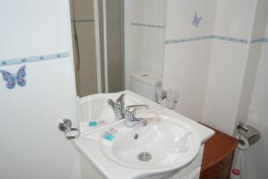 biała łazienka z umywalką i lustrem w obiekcie Carabeo 15 Studios Casasol w mieście Nerja