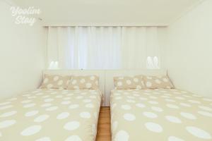 two beds in a bedroom with white curtains at Yoolim stay # 건대입구# 성수# 잠실롯데타워 in Seoul