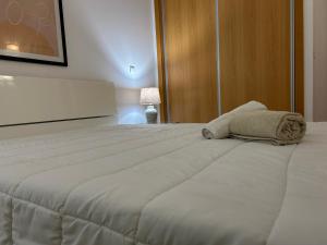 a large white bed with a pillow on top of it at ConVistaApartment with Pool in Portimão +37 photos