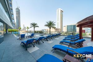 a row of blue chairs on a patio with buildings at Captivating Sky & Sea Views in Two Bedroom Suite in Dubai