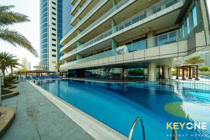 a large building with a swimming pool in front of it at Captivating Sky & Sea Views in Two Bedroom Suite in Dubai