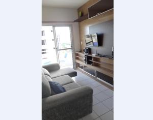 a living room with a couch and a tv at Ajuricaba Suites 6 in Manaus