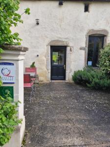 a house with a black door and a red chair at LES DIVINES BOURGOGNE in La Rochepot