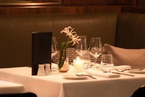 a table with wine glasses and a vase with flowers at The Guesthouse Vienna in Vienna