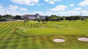 a group of people playing golf on a golf course at Bowood Park Hotel in Camelford