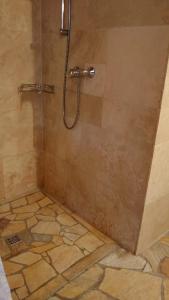 une douche dans une salle de bain avec un sol carrelé dans l'établissement Eifelurlaub - kanadisches Blockstamm Ferienhaus für 12 Personen, à Schleiden