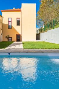 a house and a pool of water in front of a house at GuestReady - Easygoing Pool to River in Bandeira