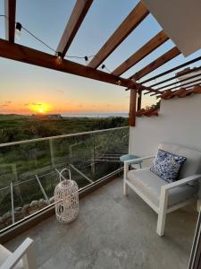 a balcony with a couch and a sunset at Breath taking seaview Apartment at Lighthouse Beach in Paphos City