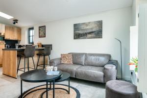 オーストカペッレにあるHello Zeeland - Vakantiewoning Noordweg 4aのソファとテーブルのあるリビングルーム