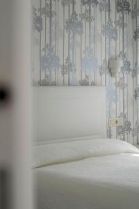 a bedroom with a bed and a blue and white wall at Apartamento San Miguel N.3 in Jarandilla de la Vera