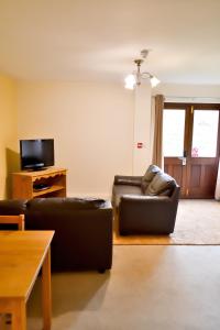 a living room with two couches and a tv at Bowood Park Hotel in Camelford