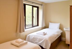 two beds in a room with a window at Bowood Park Hotel in Camelford