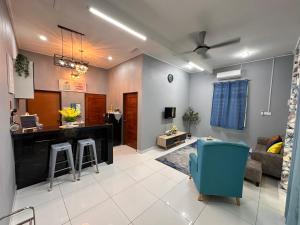 a living room with a bar and a blue chair at Tok Wan's Studio Homestay in Tanah Merah