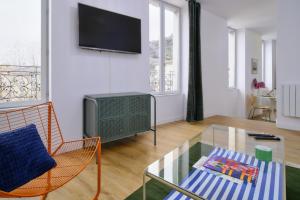 ヴィエンヌにあるLe Marty, T2 inoubliable, confort et styleのリビングルーム(ガラスのコーヒーテーブル、テレビ付)