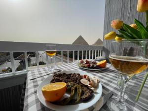 een bord eten op tafel met een glas wijn bij Colorful Pyramid Home in Caïro
