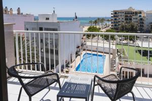 a balcony with two chairs and a swimming pool at Hotel Amic Miraflores in Can Pastilla