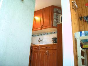 una cocina con armarios de madera y fregadero en Anita Haus, en Gárdony