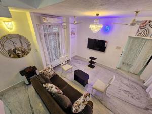 un soggiorno con un divano e una TV di Anton White Villas Resort a Mamallapuram