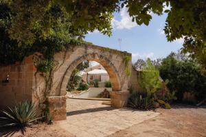 een stenen boog in een tuin met een huis bij B&B villa Gallo in Torre Squillace