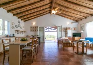 a living room with wooden ceilings and tables and chairs at Villa Clara in Tertenìa