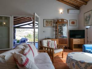 a living room with a couch and a tv at Villa Clara in Tertenìa
