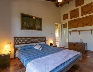a bedroom with a large bed with a blue comforter at Villa Clara in Tertenìa