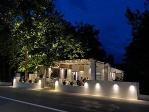 a white building with lights on a street at night at Paris Studios & Apartment in Agia Paraskevi