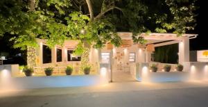 a white building with potted plants and lights at Paris Studios & Apartment in Agia Paraskevi