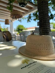 a straw hat sitting on top of a table at Paris Studios & Apartment in Agia Paraskevi