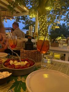 a table with a plate of food and glasses of wine at Paris Studios & Apartment in Agia Paraskevi