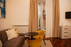 un salon avec un canapé, une table et des chaises dans l'établissement HELLO CHIAIA NAPOLI by Progecta srl, à Naples