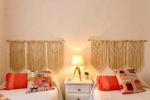 a bedroom with two beds and a lamp on a night stand at Esmeralda HOME JÁVEA in Jávea