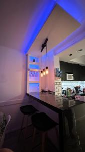 eine Küche mit violetter Beleuchtung und einer Theke mit Stühlen in der Unterkunft Departamento frente al mar entre Guemes y Olavarria in Mar del Plata + 26 Fotos