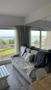 ein Wohnzimmer mit Couch und großem Fenster in der Unterkunft Departamento frente al mar entre Guemes y Olavarria in Mar del Plata