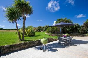 a table and chairs and an umbrella on a patio at Tipoz'Immo Ti Marin beach accessrestaurants on foot in Plovan