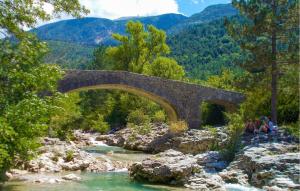 un puente de piedra sobre un río con gente sentada en las rocas en Lovely Home In Carpentras With Wifi, en Carpentras