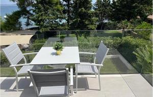 Una mesa blanca y sillas en un patio. en 1 Bedroom Awesome Apartment In Ugljan, en Ugljan