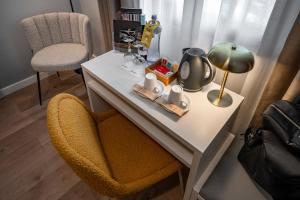 Un escritorio con una silla y una lámpara encima. en SERHS Carlit Boutique Hotel, en Barcelona