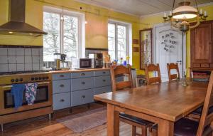 a kitchen with a wooden table and a wooden dining table at Beautiful Home In Smedstorp With Wifi in Smedstorp