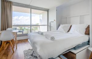 ein Schlafzimmer mit einem großen Bett mit einem großen Fenster in der Unterkunft Gorgeous Apartment In La Rochelle in La Rochelle