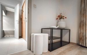 a hallway with a table with a stool and a vase at 2 Bedroom Nice Apartment In Oostende in Ostend