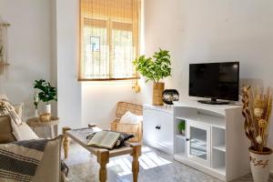 a living room with a flat screen tv on a white cabinet at Esmeralda HOME JÁVEA in Jávea